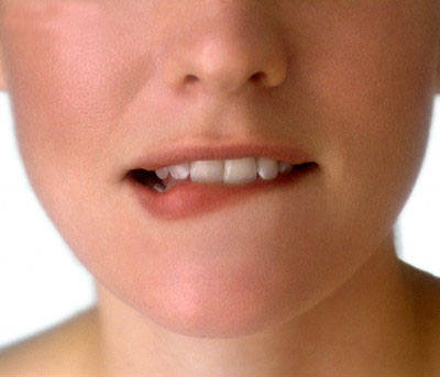 Woman Biting Lip --- Image by © Jupiterimages/Brand X/Corbis