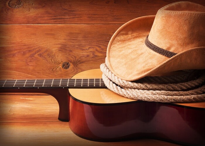 A cowboy hat and a rope set on a guitar