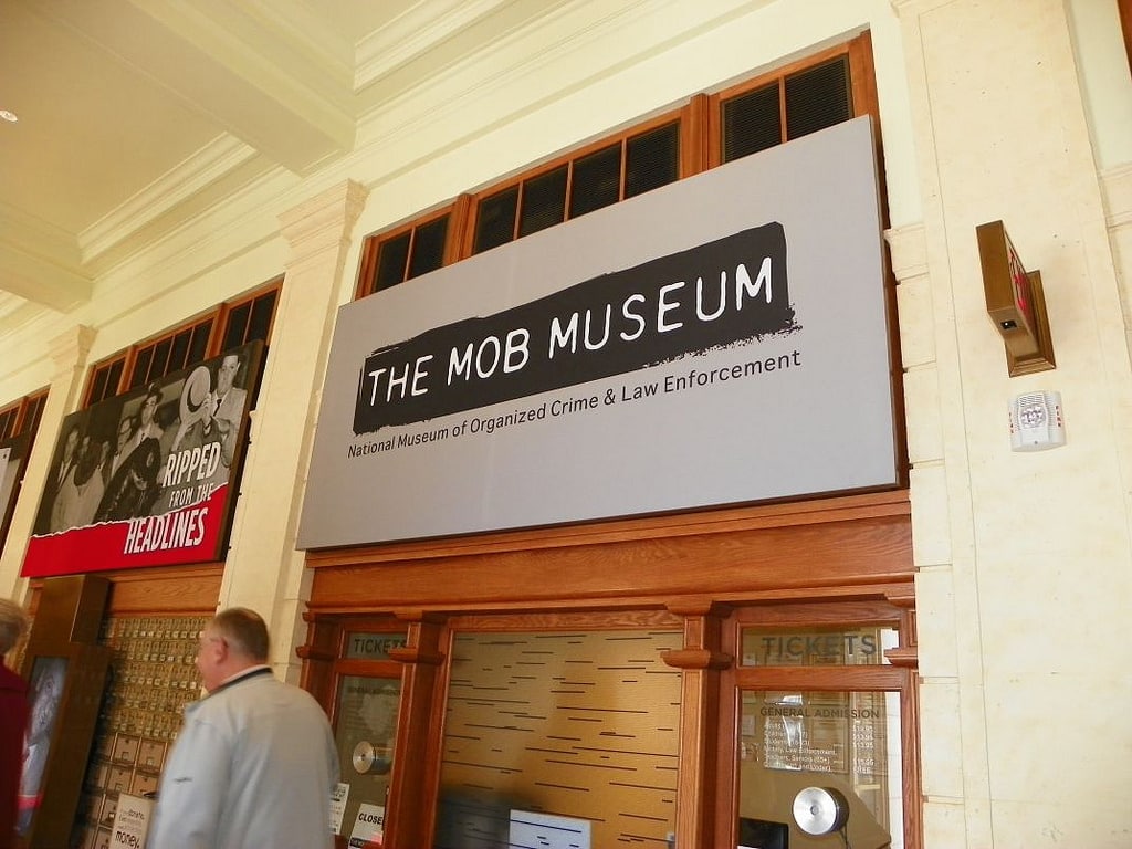 a man passing by the signage written the mob museum with other signage too