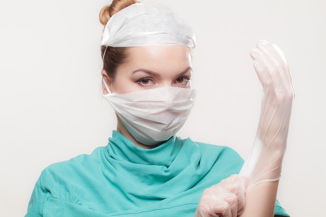 a female doctor putting on surgical gloves
